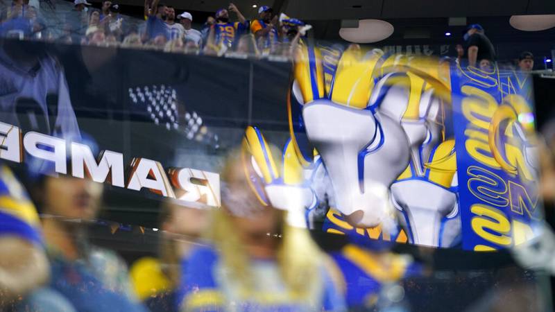 Fans are seen behind logos from the Los Angeles Rams at SoFi stadium during the first half of...